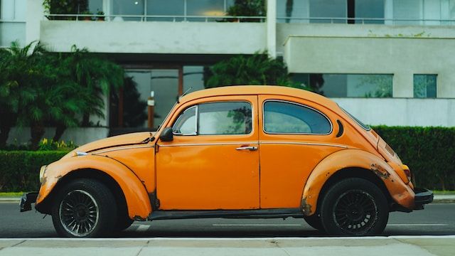Image of range vintage car parked sideways on the street